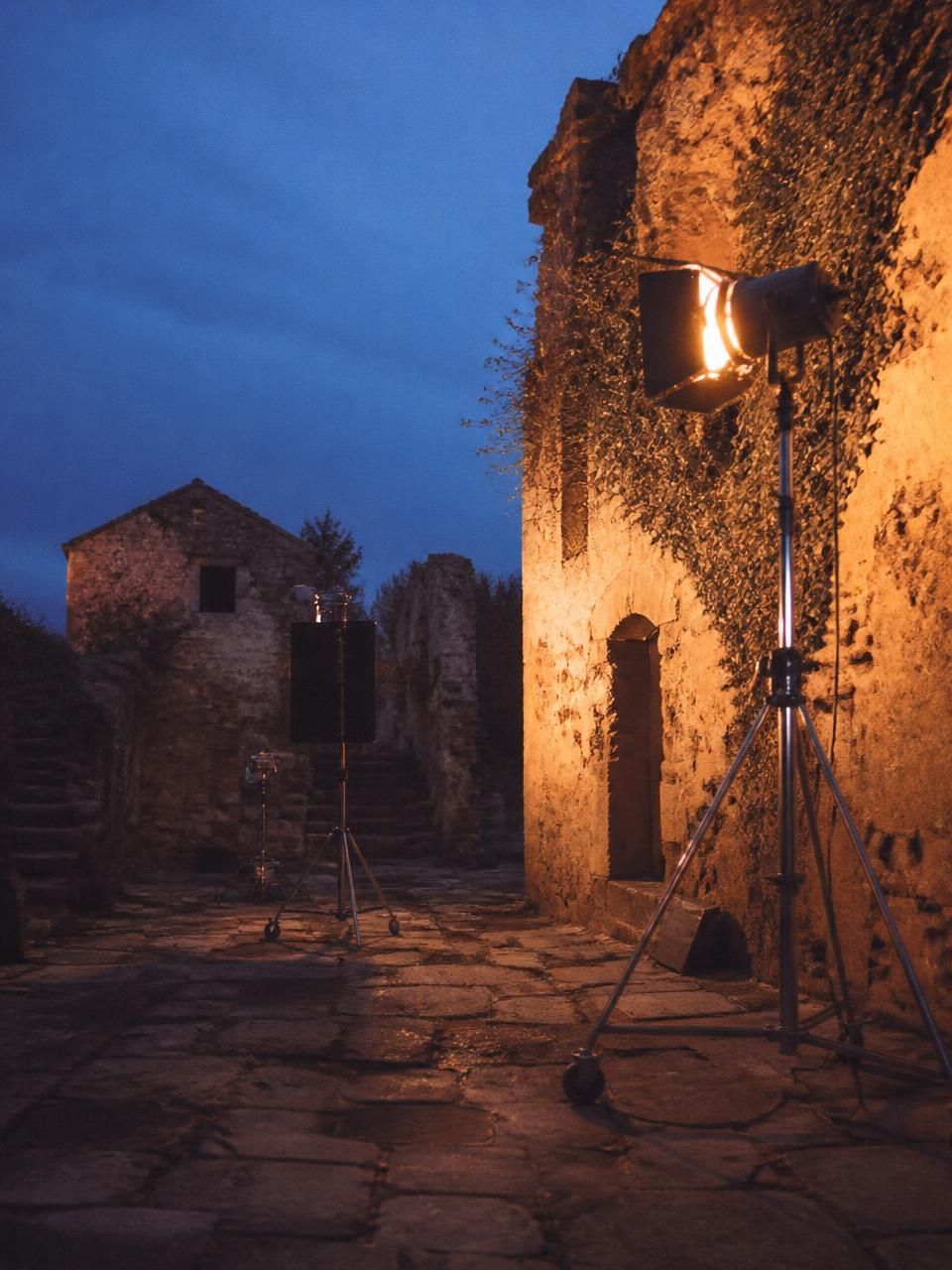 Attrezzatura da ripresa in un vicolo del borgo antico all'imbrunire
